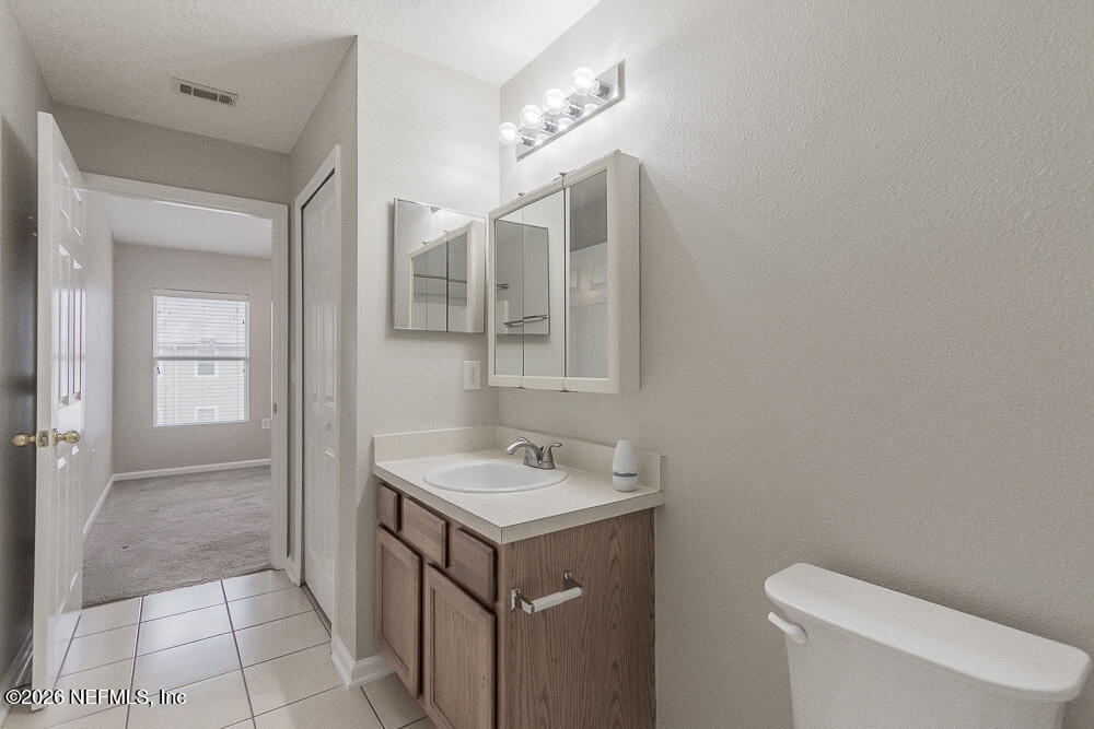 7920 Merrill Road, Unit 1511 Jacksonville, FL 32277 - Photo 27 of 32 a bathroom with a sink a toilet and mirror