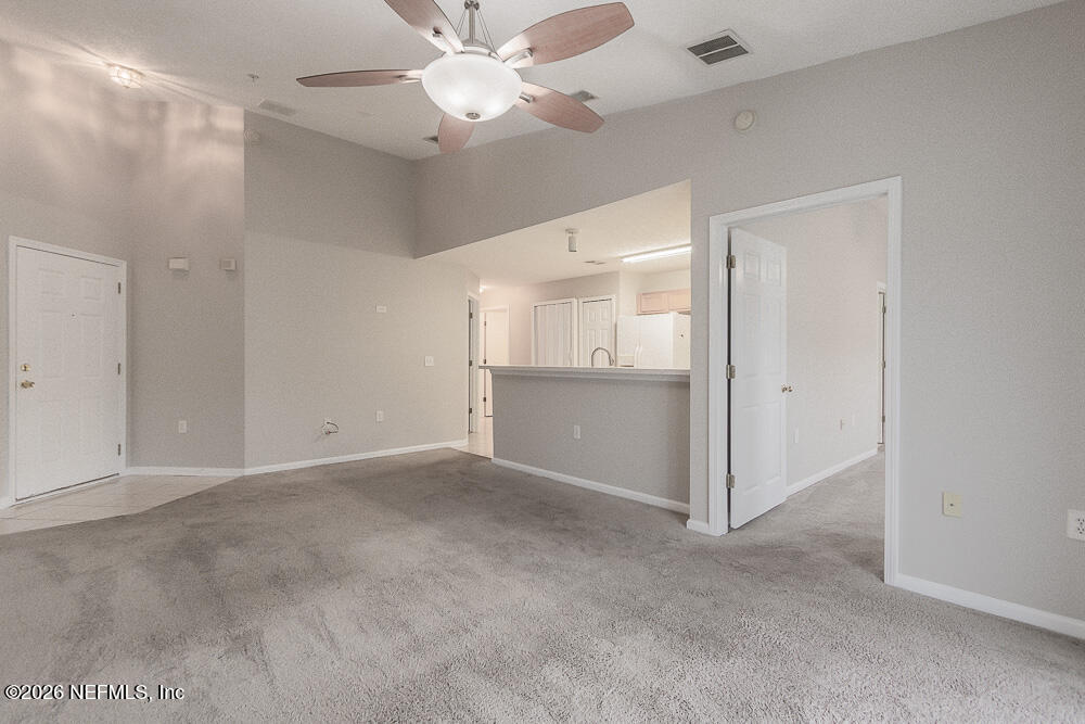 7920 Merrill Road, Unit 1511 Jacksonville, FL 32277 - Photo 9 of 32 an empty room with a ceiling fan and a bathroom
