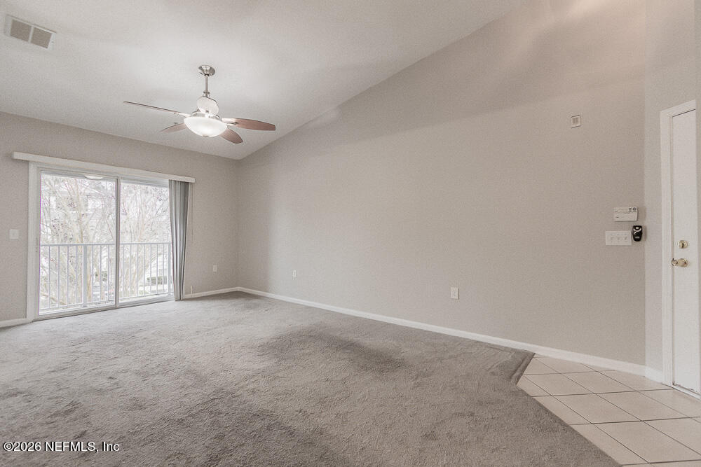 7920 Merrill Road, Unit 1511 Jacksonville, FL 32277 - Photo 10 of 32 an empty room with chandelier fan and windows