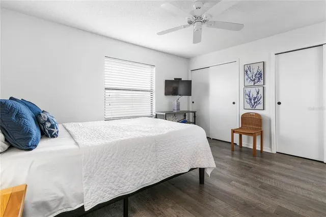 a bedroom with a bed a table and painting on the wall