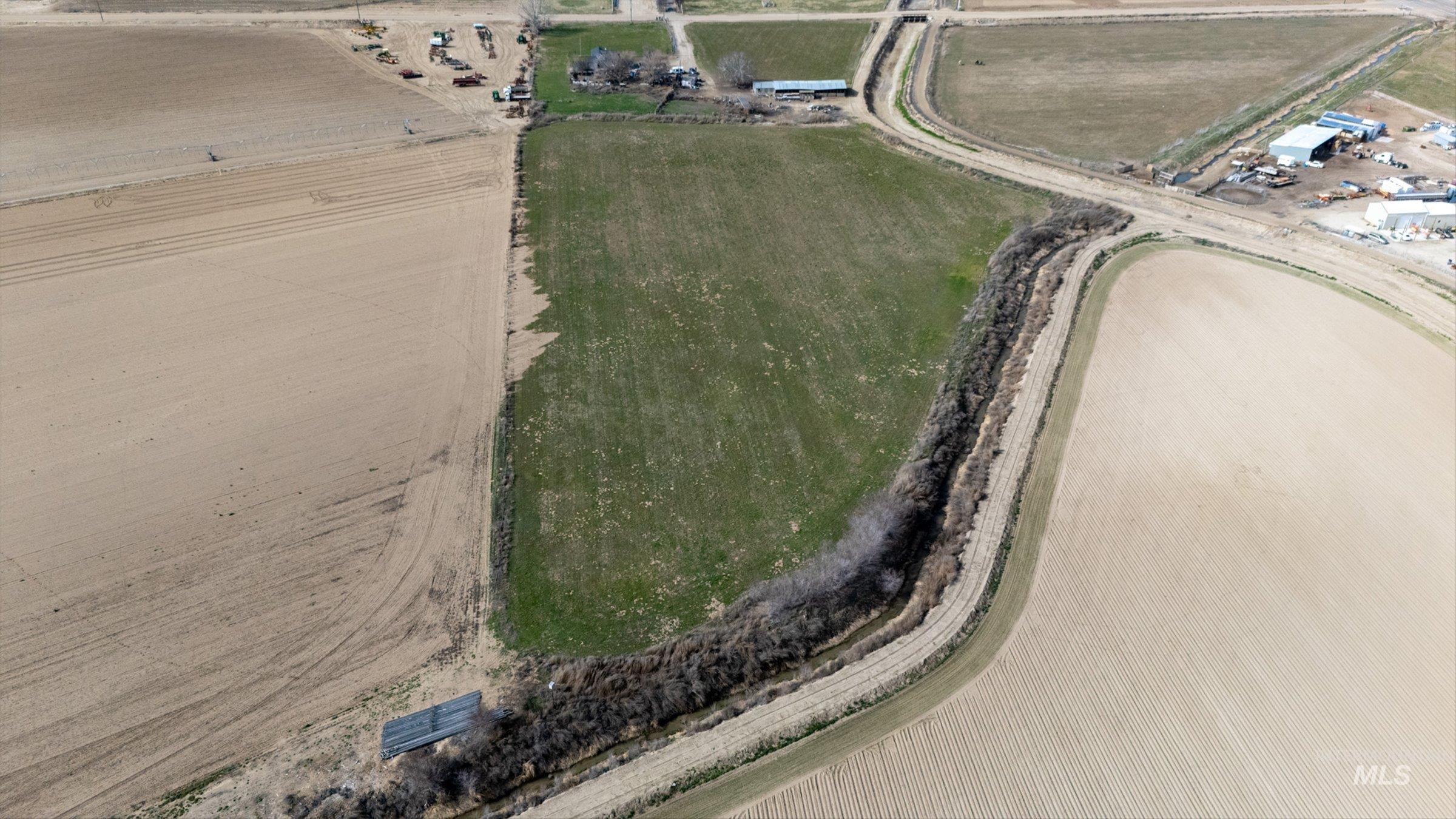 20286 Travis Road Wilder, ID 83676 - Photo 9 of 27 Aerial view of property and surrounding area with rural landscape and rows of crops