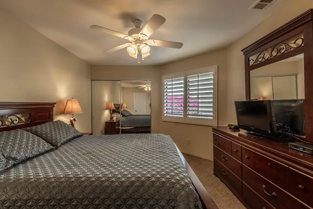 a bathroom with a granite countertop sink a toilet a mirror and shower