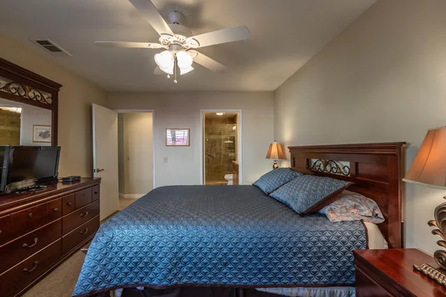 a bathroom with a granite countertop sink a toilet a mirror and shower