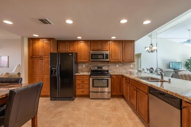 a kitchen with stainless steel appliances granite countertop a sink and stove top oven