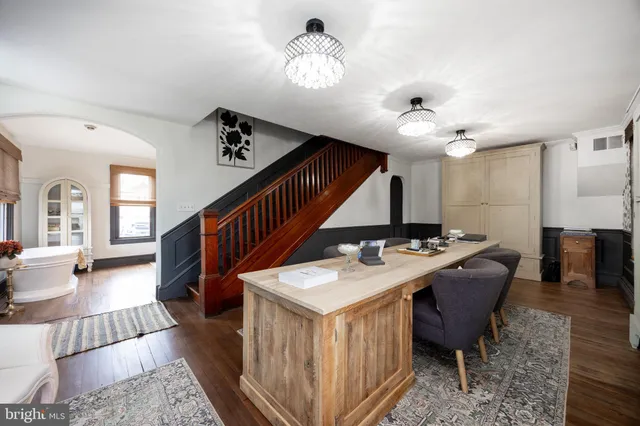 a view of a livingroom with furniture a rug a chandelier and windows