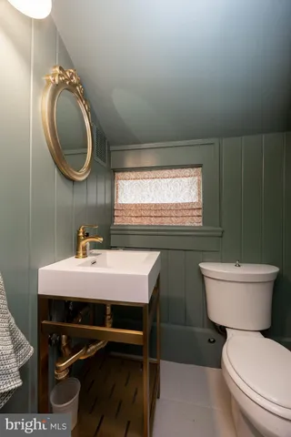 a bathroom with a toilet a sink and mirror