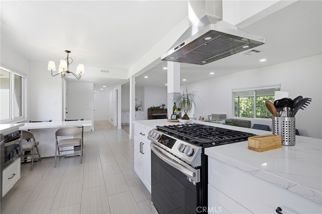 384 Colorado Street Arcadia, CA 91007 - Photo 21 of 51 a kitchen with stainless steel appliances granite countertop a stove a sink dishwasher and a dining table with the kitchen island