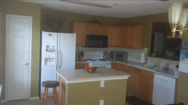 a kitchen with stainless steel appliances a refrigerator a sink a stove and cabinets