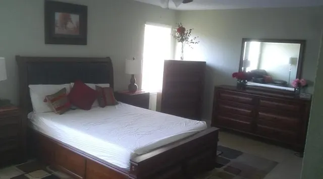 a bedroom with a bed and a mirror on dresser