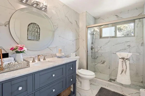 a bathroom with a granite countertop sink and a mirror