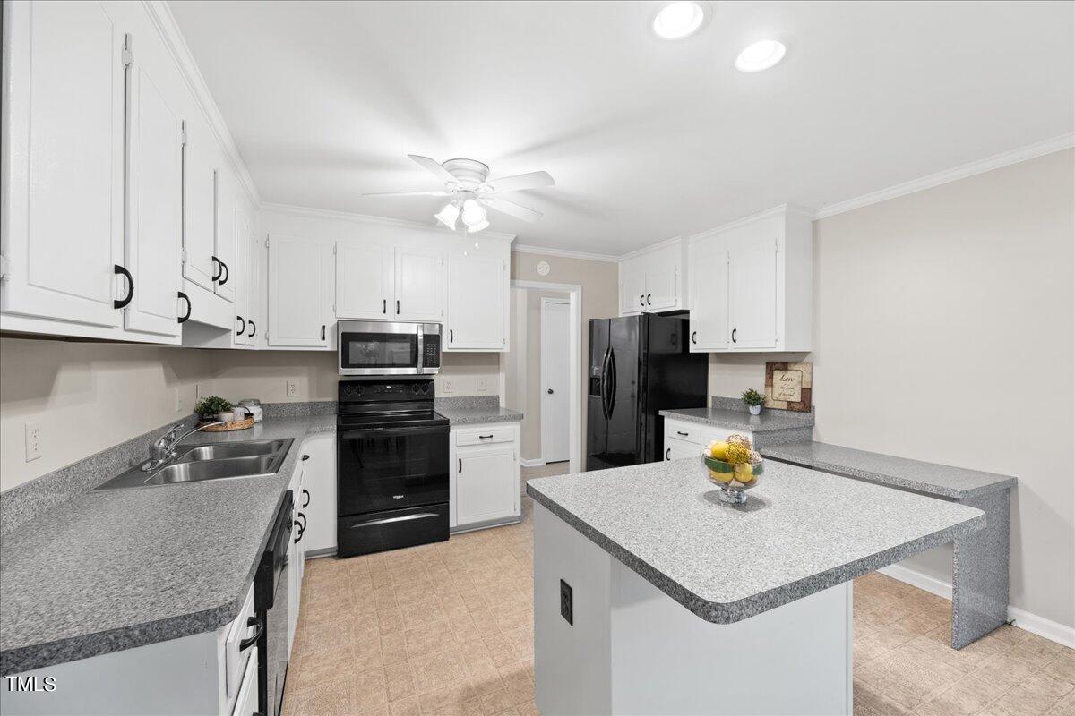 1408 Roy Averette Drive Raleigh, NC 27603 - Photo 12 of 31 a kitchen with a sink a stove and refrigerator