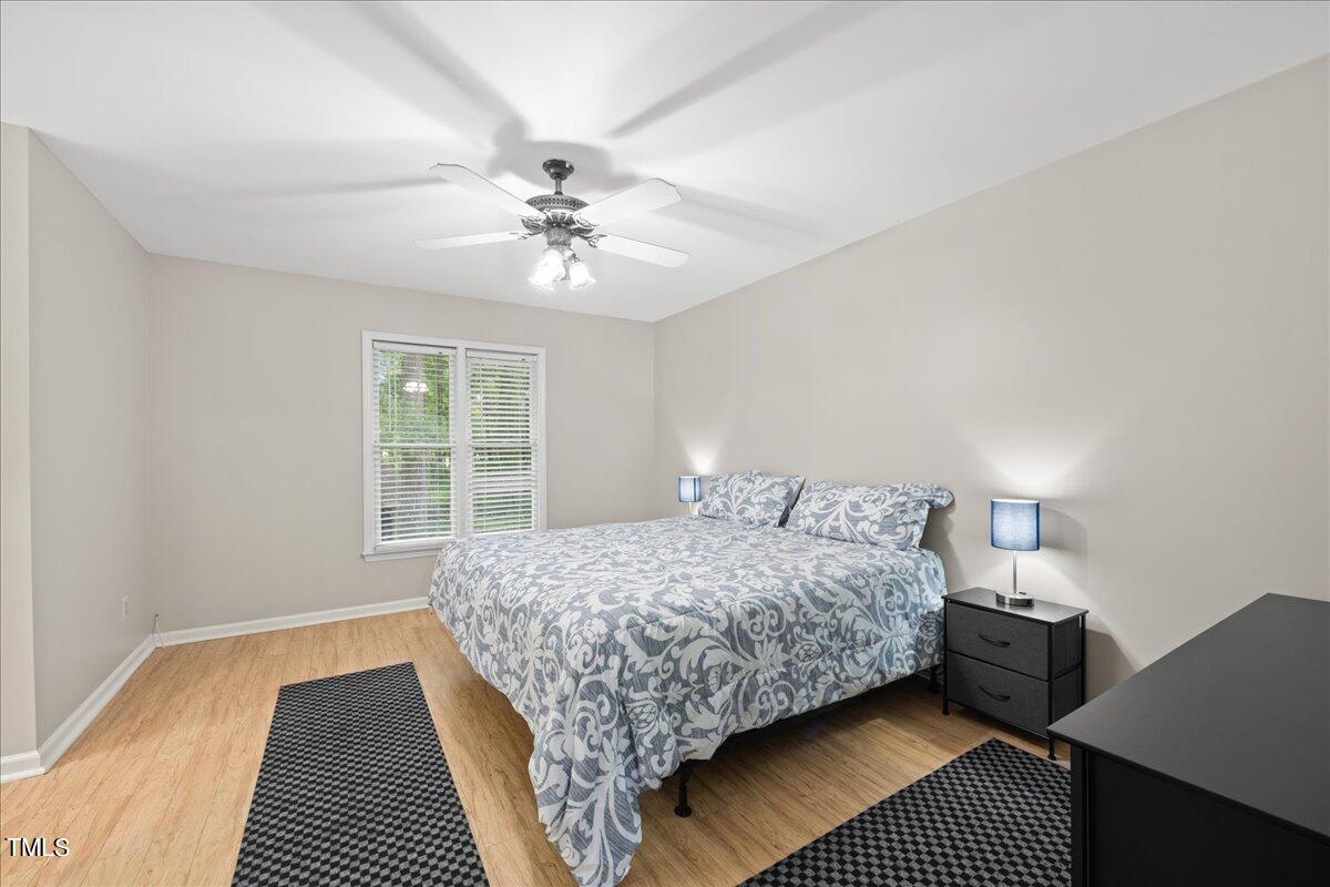 1408 Roy Averette Drive Raleigh, NC 27603 - Photo 16 of 31 a bedroom with a large bed chandelier and a window