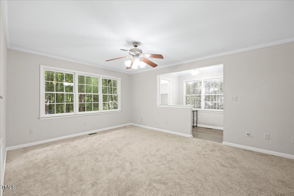 1408 Roy Averette Drive Raleigh, NC 27603 - Photo 9 of 31 an empty room with windows and chandelier fan