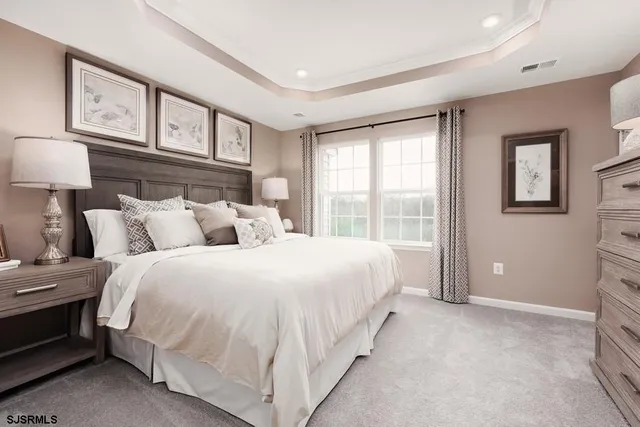 a spacious bedroom with two beds and painting on the wall