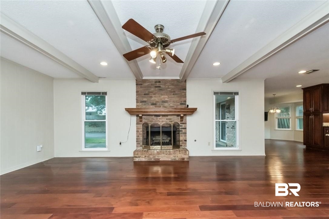 6109 Timberly Road North Mobile, AL 36609 - Photo 8 of 26 Unfurnished living room with a fireplace, beam ceiling, dark hardwood / wood-style flooring, and ceiling fan