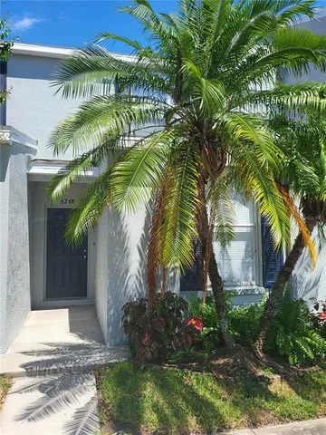 a front view of multi story residential apartment building with yard and sign board