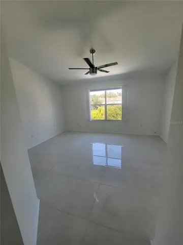 an empty room with windows and fan