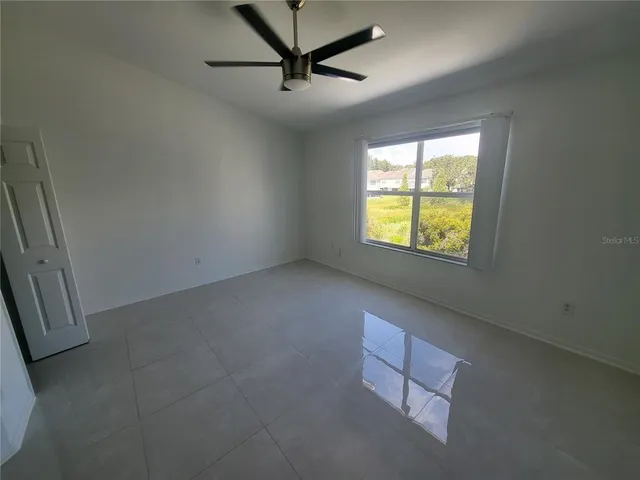 a view of a room with a ceiling fan and wooden floor
