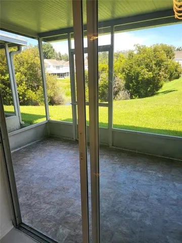 a view of an empty room with wooden floor and a floor to ceiling window