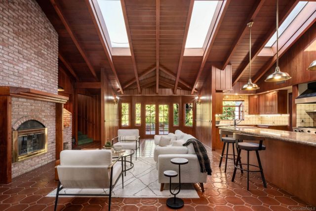a living room with furniture fireplace and potted plants