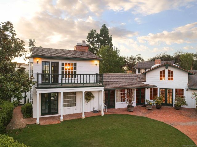 a front view of a house with a garden and yard