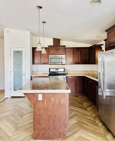 a kitchen with stainless steel appliances granite countertop a stove a sink and a refrigerator