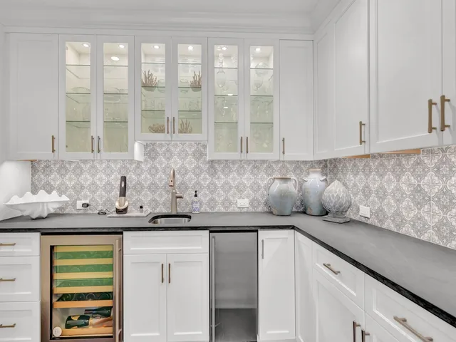 a kitchen with stainless steel appliances granite countertop a sink and a white cabinets