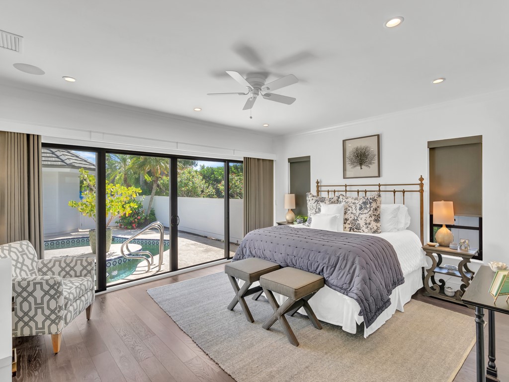 245 Springline Drive Vero Beach, FL 32963 - Photo 14 of 35 a spacious bedroom with a large bed and a chandelier