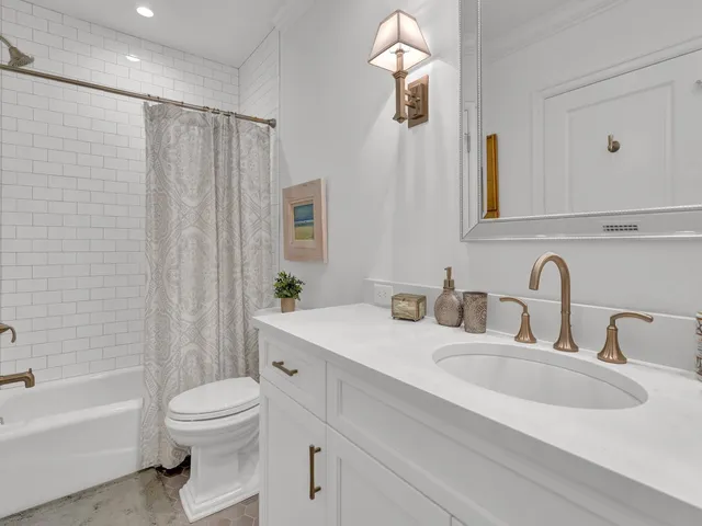 a bathroom with a double vanity sink toilet and shower