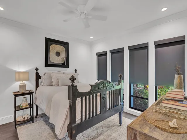 a bedroom with a bed a lamp and a large window