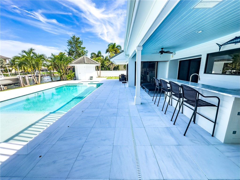 245 Springline Drive Vero Beach, FL 32963 - Photo 27 of 35 a view of a patio with table and chairs potted plants and a palm tree