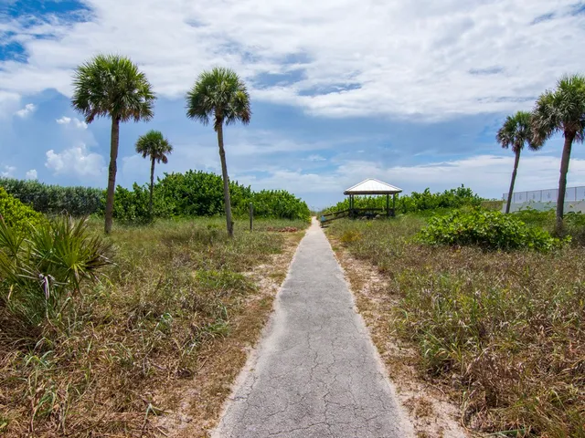 a front view of a house with a yard and potted plants