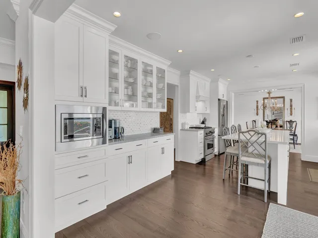 a kitchen with white cabinets and sink