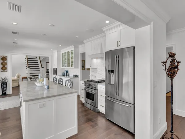 a kitchen with stainless steel appliances granite countertop a refrigerator a stove a sink and a refrigerator