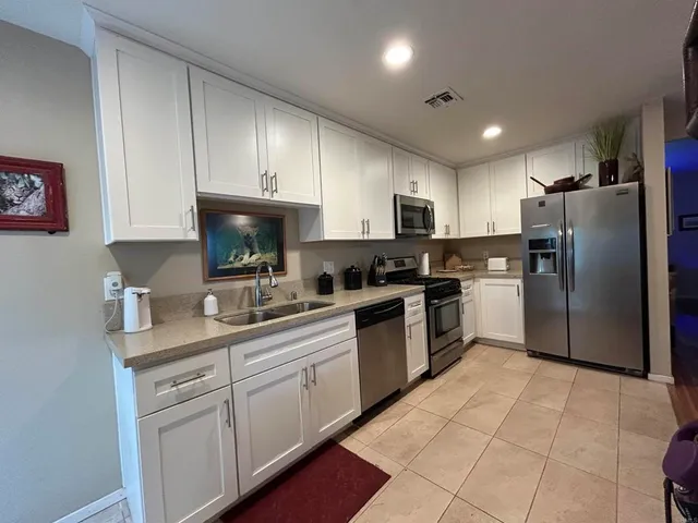 a kitchen with a refrigerator sink and cabinets