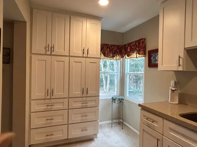 a view of a workspace with bookshelf and a window