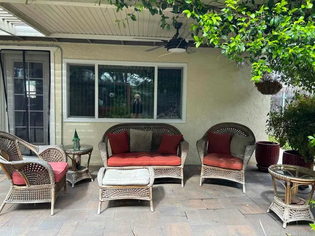 a view of a workspace with furniture and a window