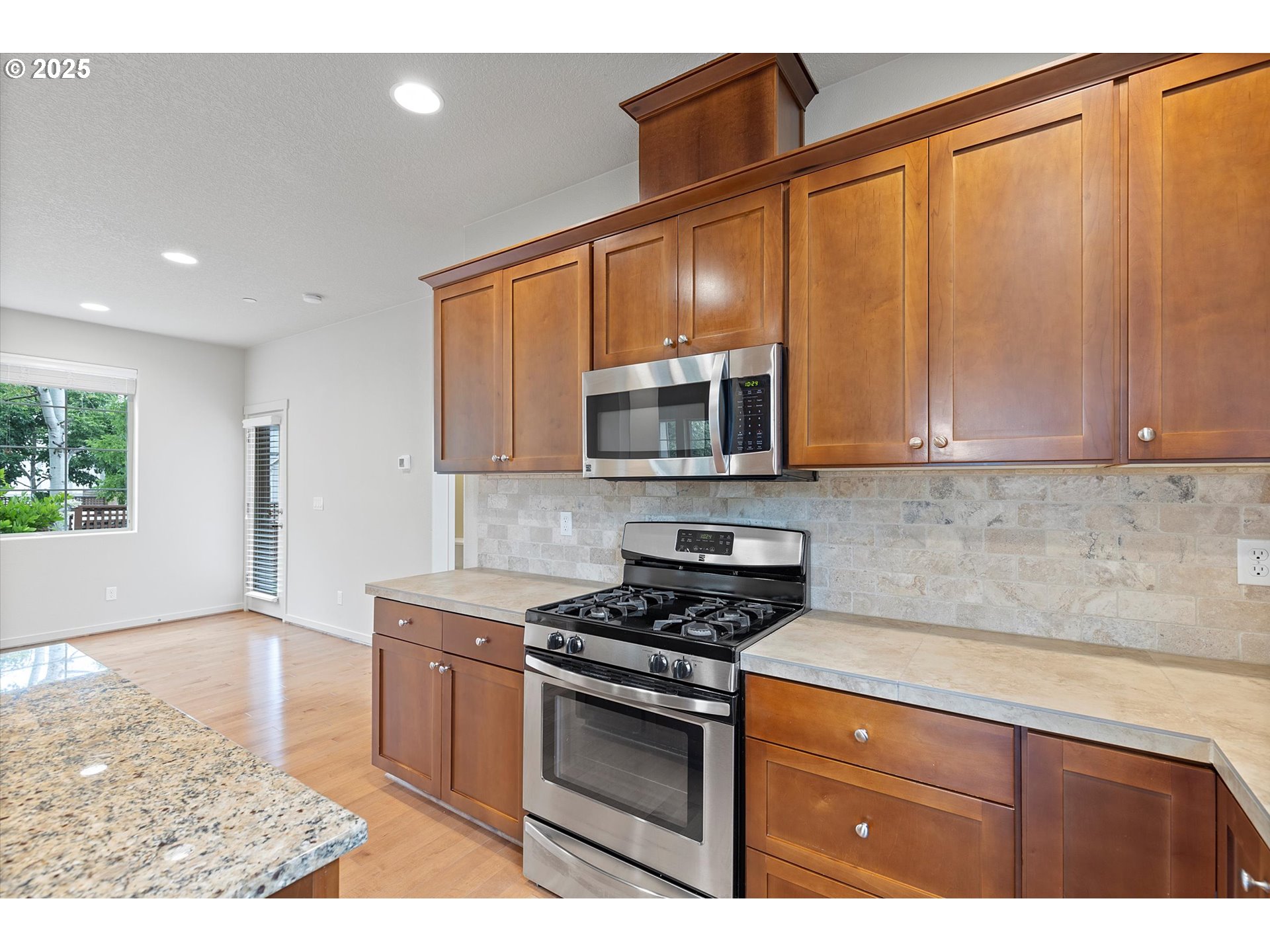 12001 Southwest Surrey Street Wilsonville, OR 97070 - Photo 14 of 48 a kitchen with stainless steel appliances granite countertop a stove a sink and a microwave