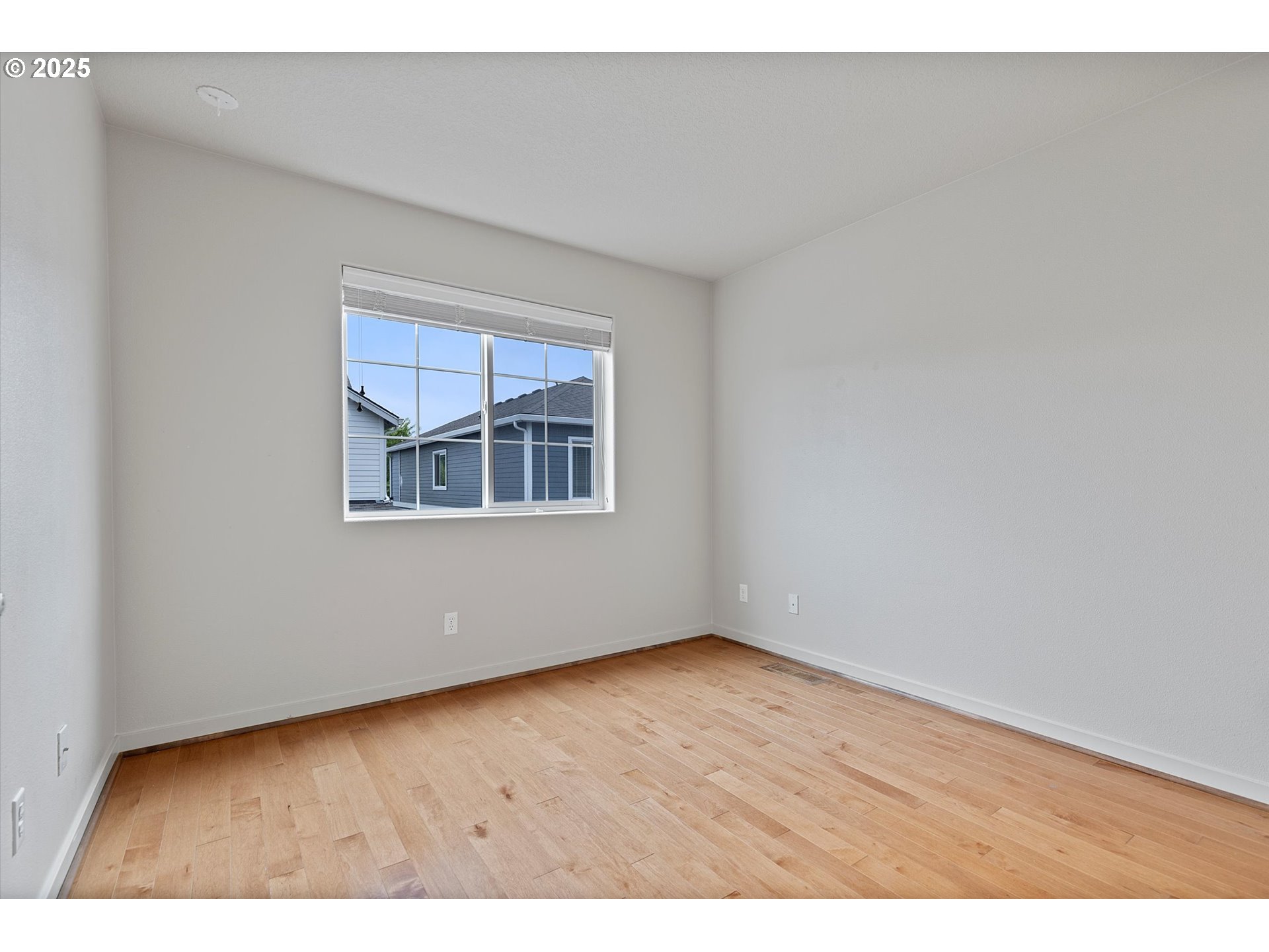 12001 Southwest Surrey Street Wilsonville, OR 97070 - Photo 22 of 48 a view of an empty room with wooden floor and a window