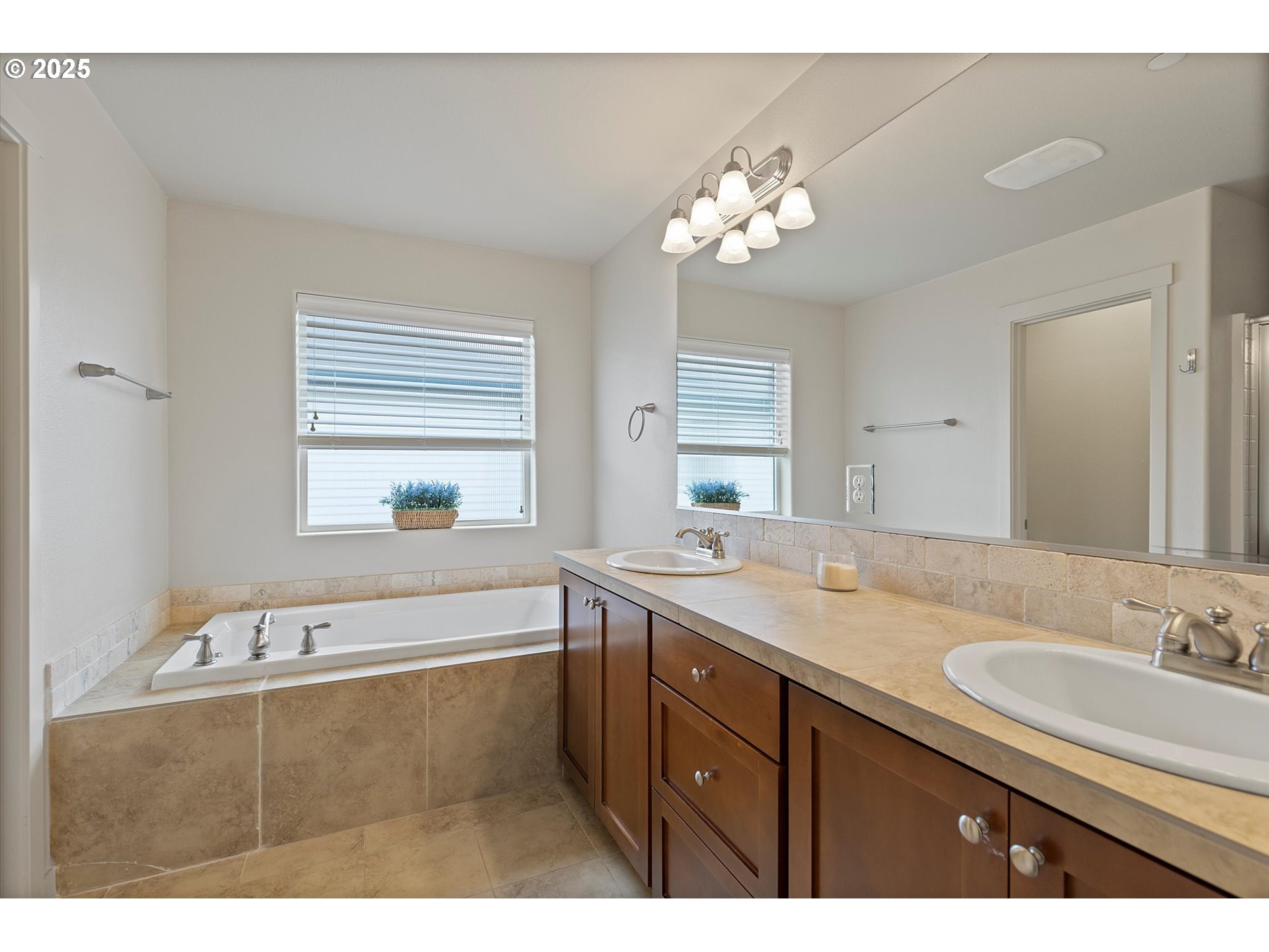 12001 Southwest Surrey Street Wilsonville, OR 97070 - Photo 39 of 48 a bathroom with a granite countertop sink a large mirror a bathtub and window