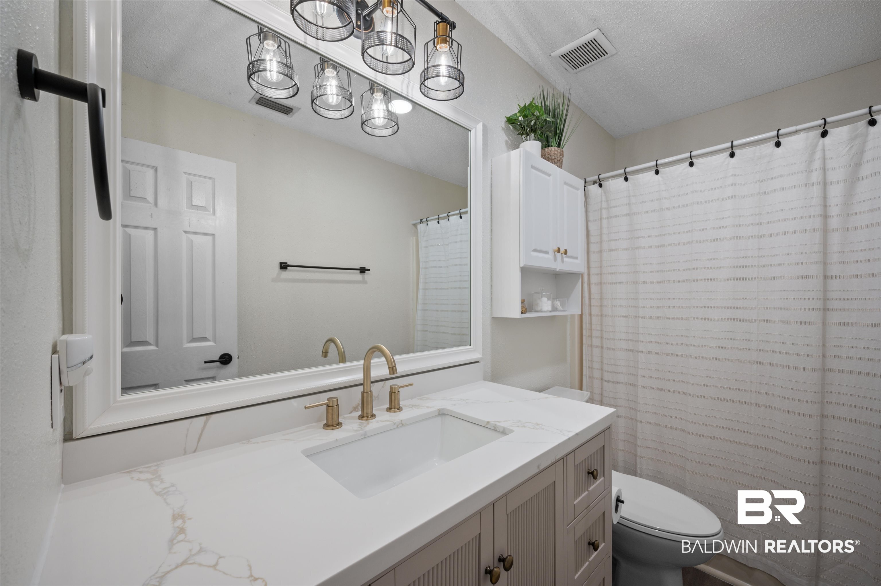 1066 Linlen Avenue Mobile, AL 36609 - Photo 18 of 22 Bathroom featuring vanity, an inviting chandelier, toilet, a textured ceiling, and visible vents