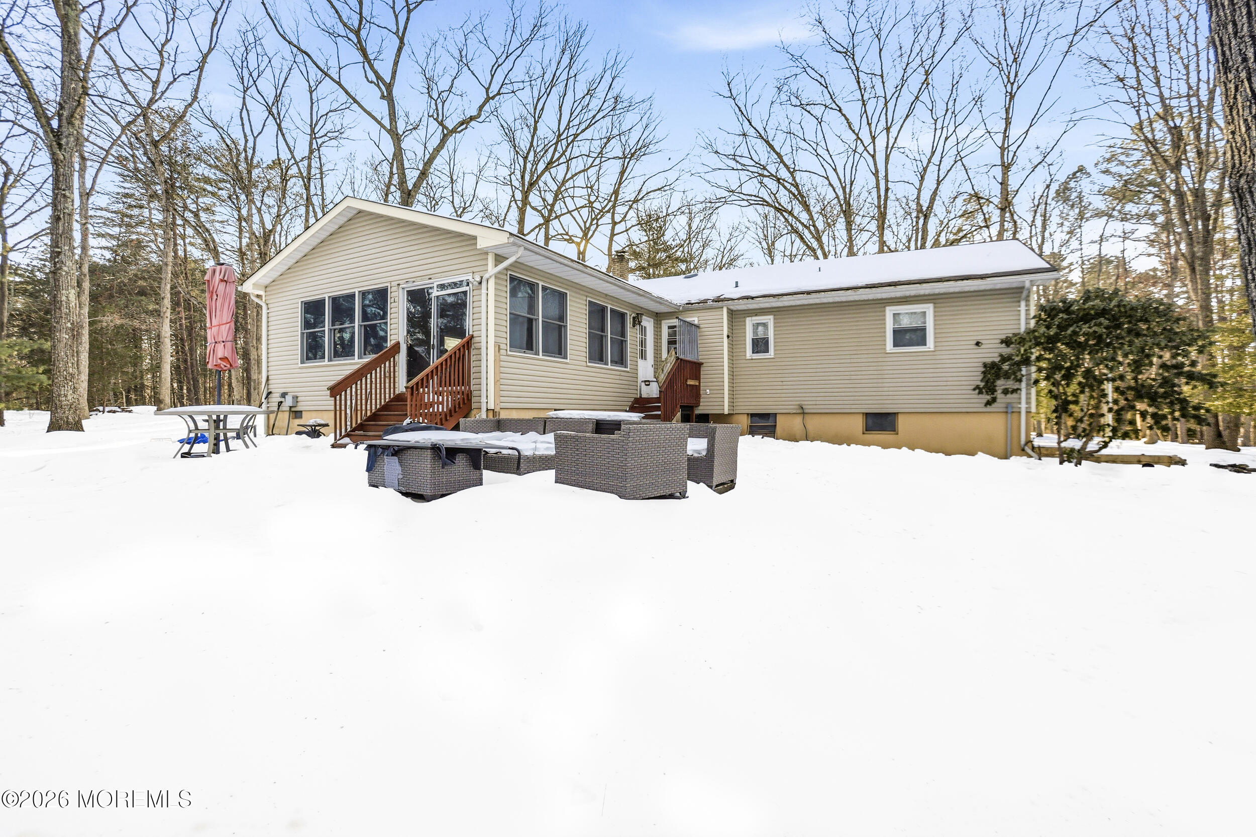 a front view of a house with a yard covered in snow