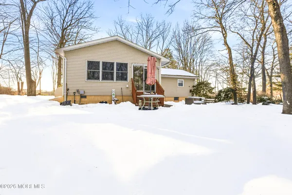 a front view of a house with a yard covered in snow
