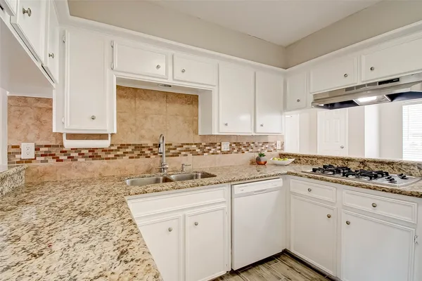 a kitchen with stainless steel appliances granite countertop a sink stove and cabinets