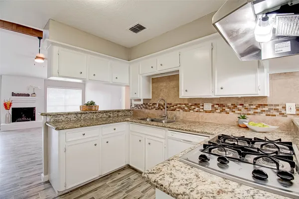 a kitchen with a sink a stove and cabinets