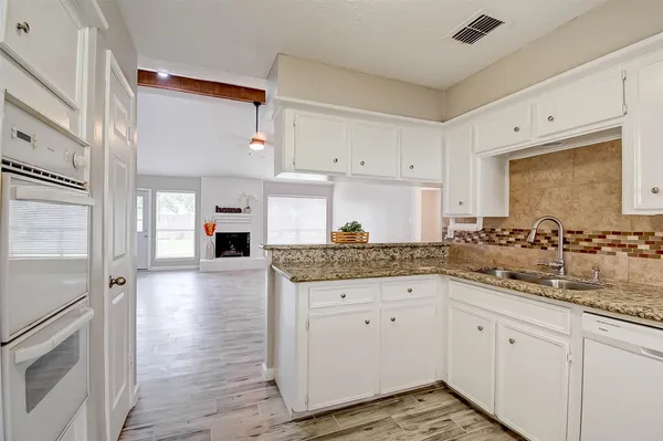 a kitchen with granite countertop a sink and cabinets
