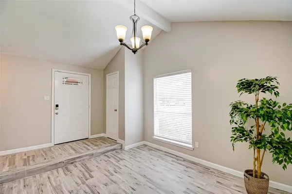 a view of empty room with wooden floor and window