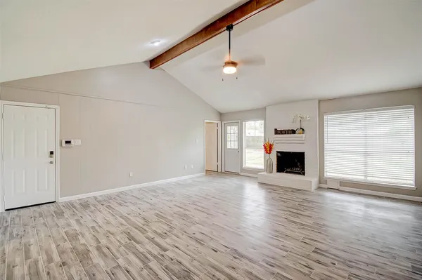 an empty room with wooden floor and window
