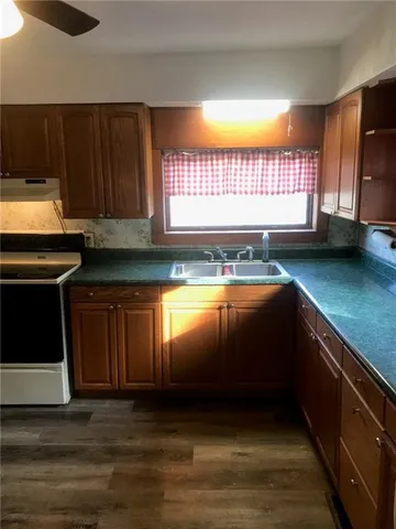 an empty room with wooden floor mirror and windows