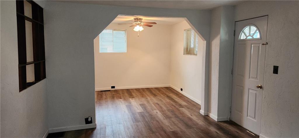 85 Dixon Road Clymer, PA 15728 - Photo 7 of 16 an empty room with wooden floor and windows